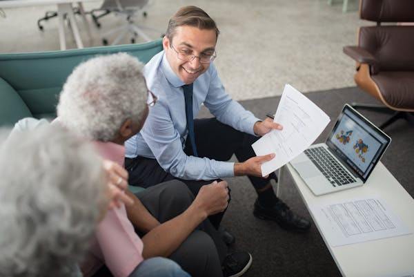 Financial advisor discussing documents with elderly couple