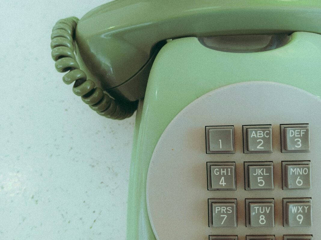 Close-up of a vintage green rotary phone