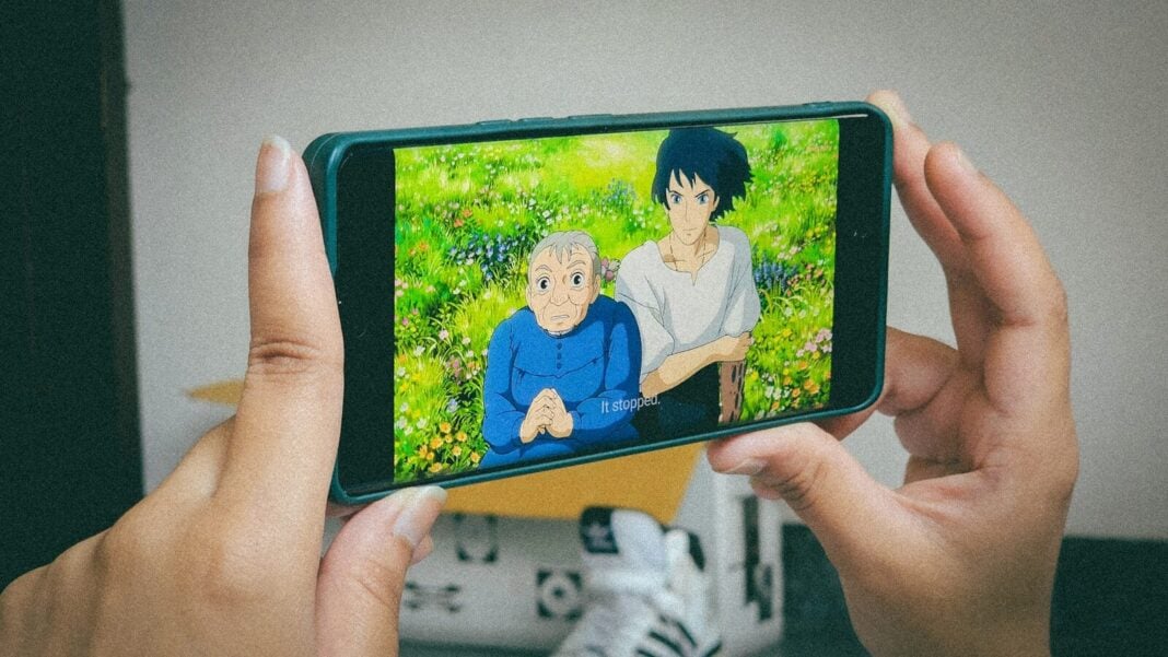 A person holding up a cell phone to take a picture