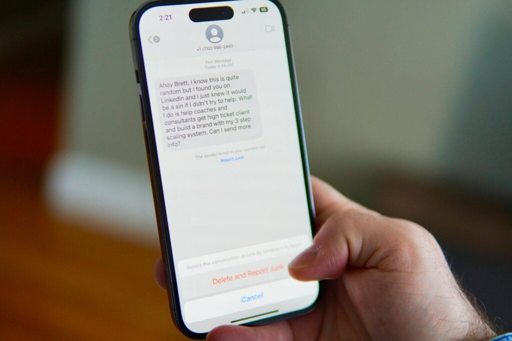 Hand holding a smartphone displaying a text message conversation.